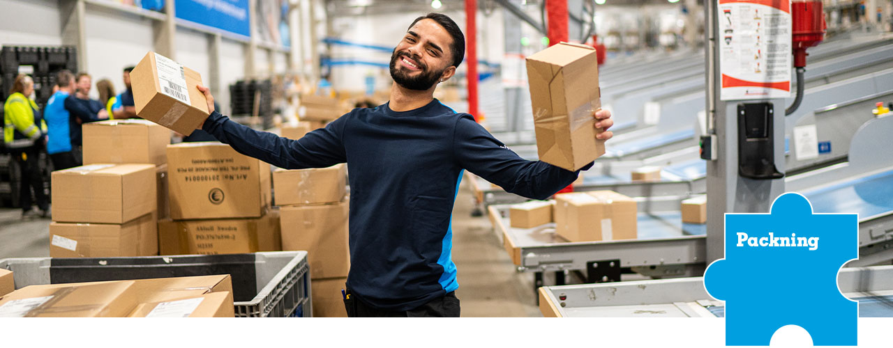 Glad man håller upp två paket i packcentral